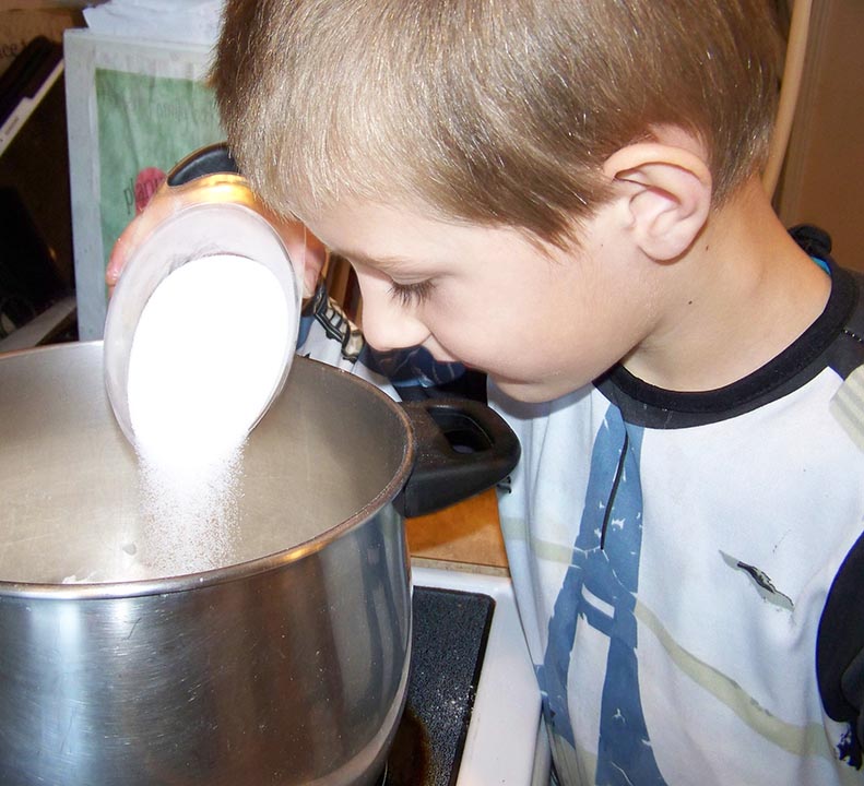 making playdough - adding the flour, salt, and cream of tartar